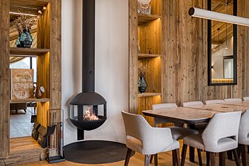 A dining room with a table and chairs and a fireplace