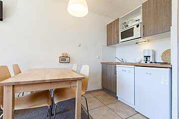A kitchen with a table and chairs and a dishwasher