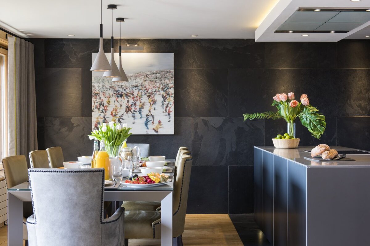 A dining room with a large painting on the wall above the table