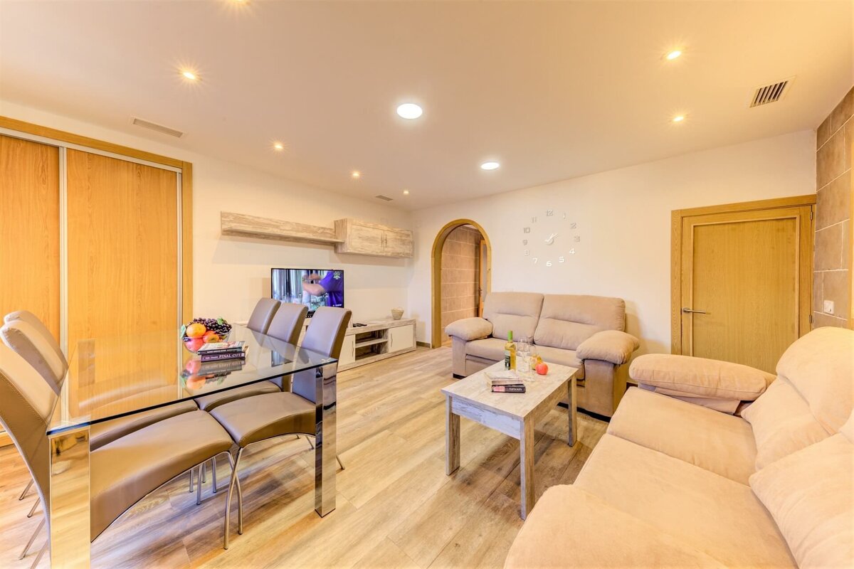 A living room with a couch and a clock on the wall