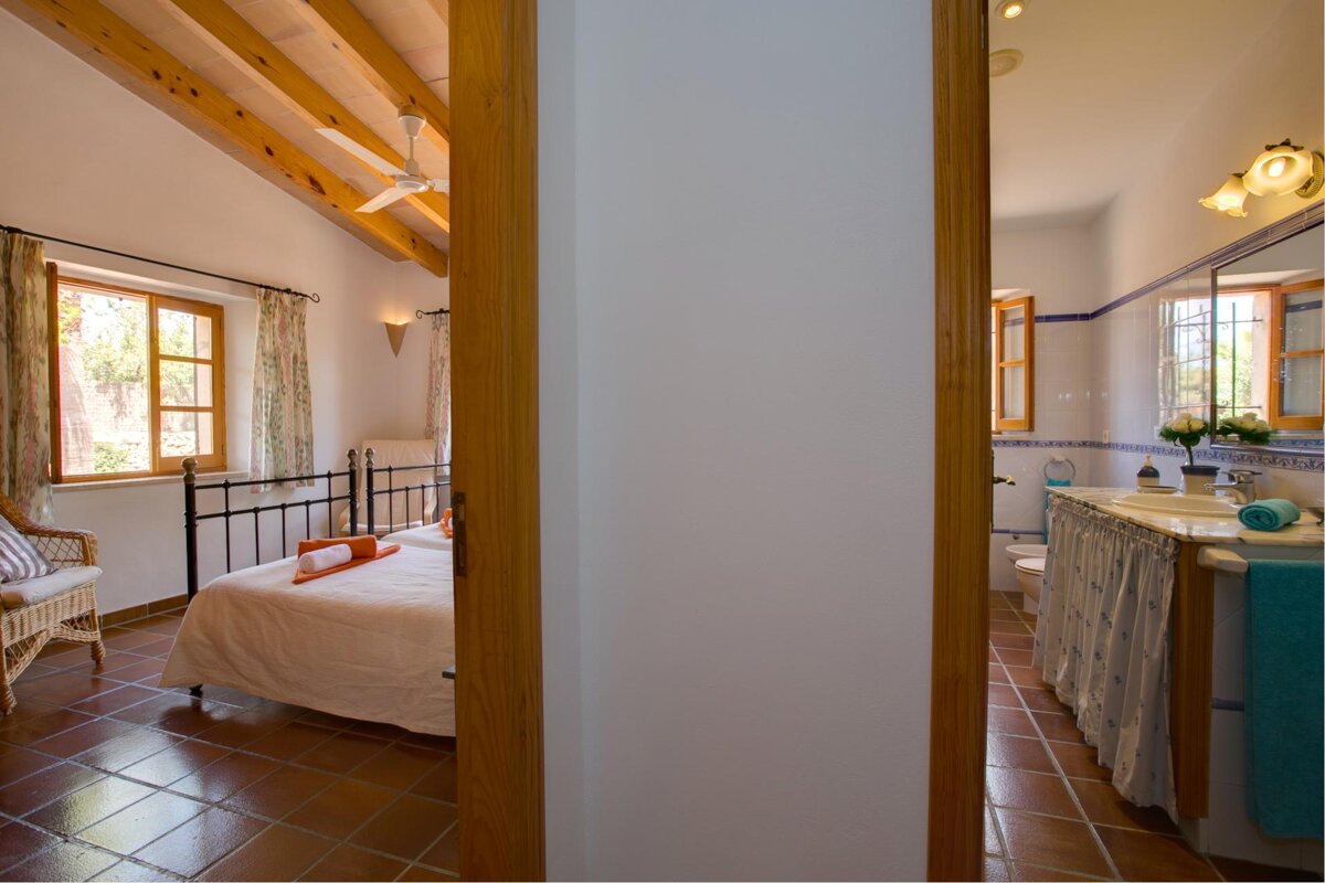 A bedroom with a bed and a bathroom with a sink