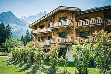 A snow covered building with mountains in the background