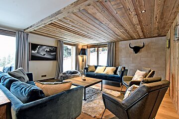 A living room with a couch and chairs and a picture on the wall