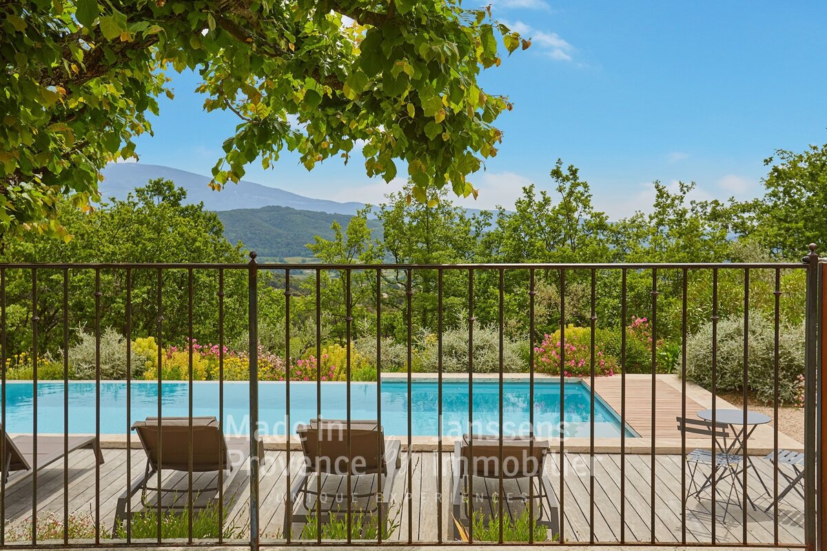 A fence surrounds a swimming pool with the words made in provence on it