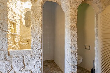 A bathroom with stone walls and a toilet