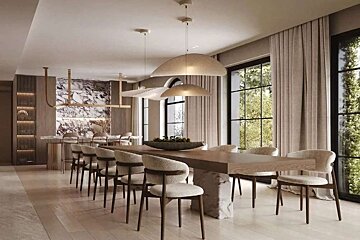 A modern, elegant dining room features a long wooden table, light chairs, unique pendant lights, and large windows with garden views.