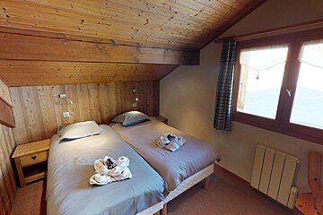 A bedroom with two beds and a window