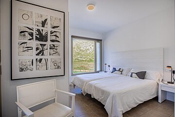 A bedroom with two beds and a painting on the wall