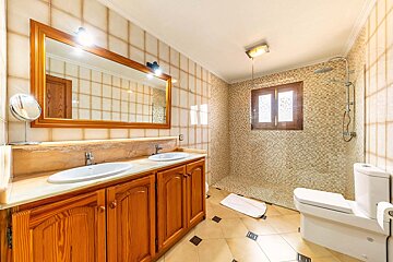 A bathroom with two sinks and a walk in shower