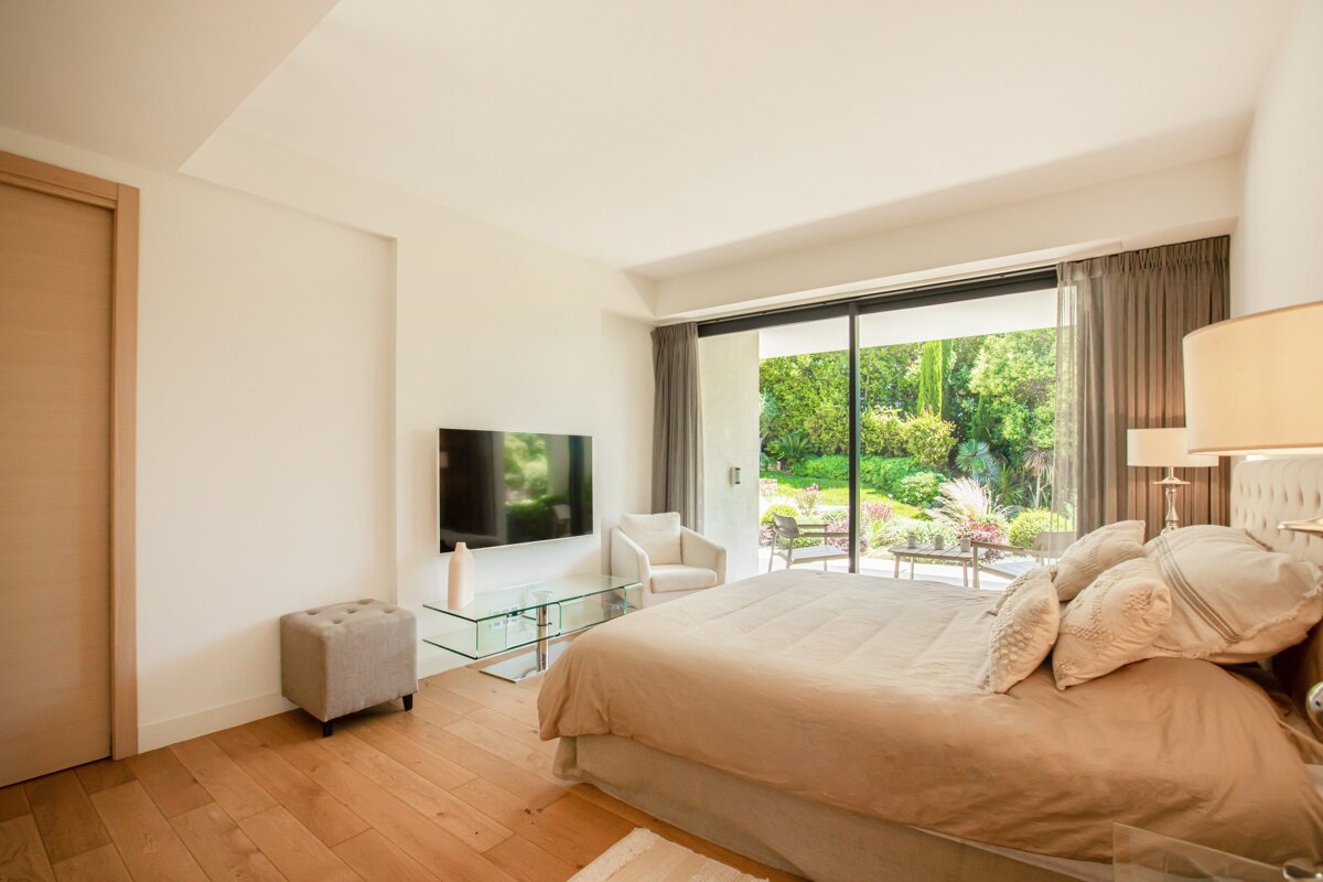 A bedroom with a large bed and a flat screen tv