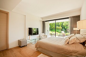 A bedroom with a large bed and a flat screen tv
