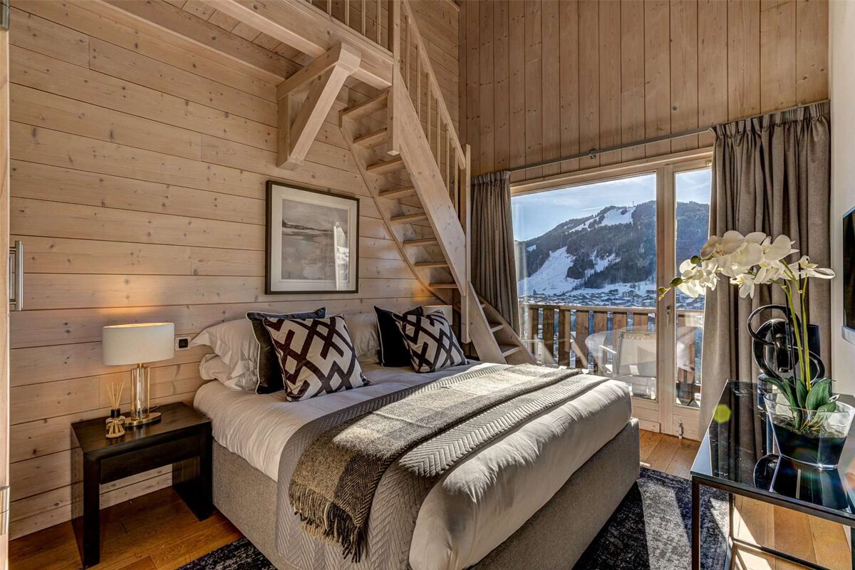 A bedroom with a staircase leading up to the second floor