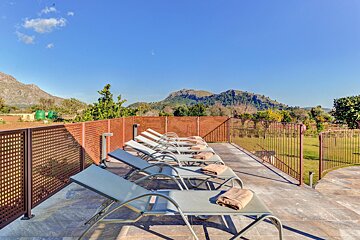 A row of lounge chairs with mountains in the background