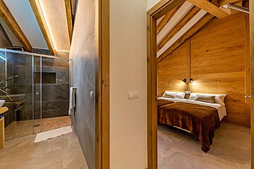 A bedroom with two beds and a walk in shower