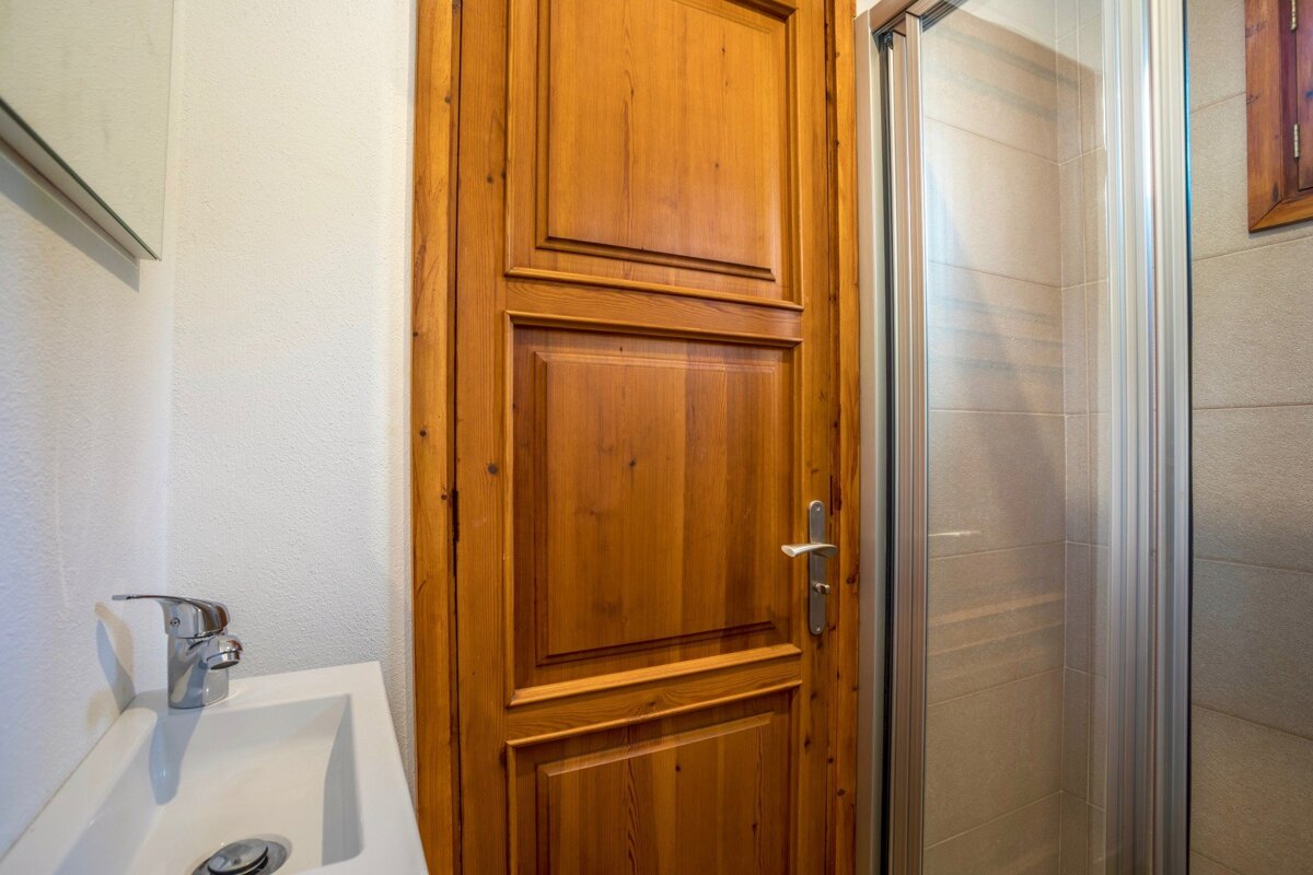 A bathroom with a sink and a wooden door