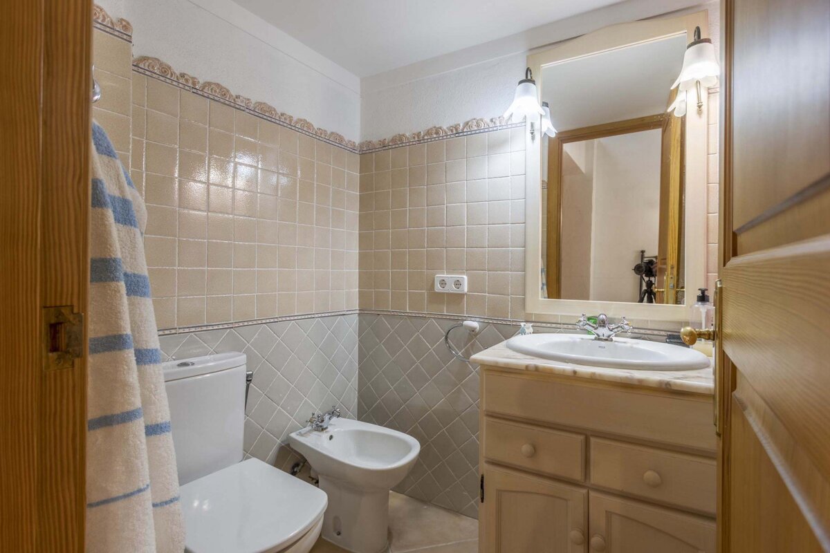 A bathroom with a toilet a sink and a mirror