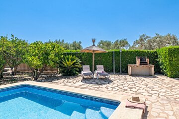 A swimming pool with chairs and an umbrella in the background