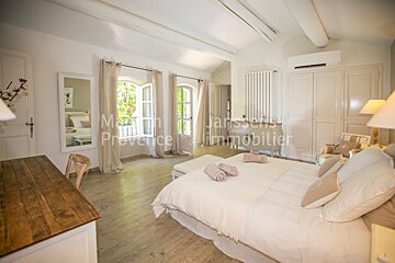 A bedroom with a large bed and a sign that says provence immobilier