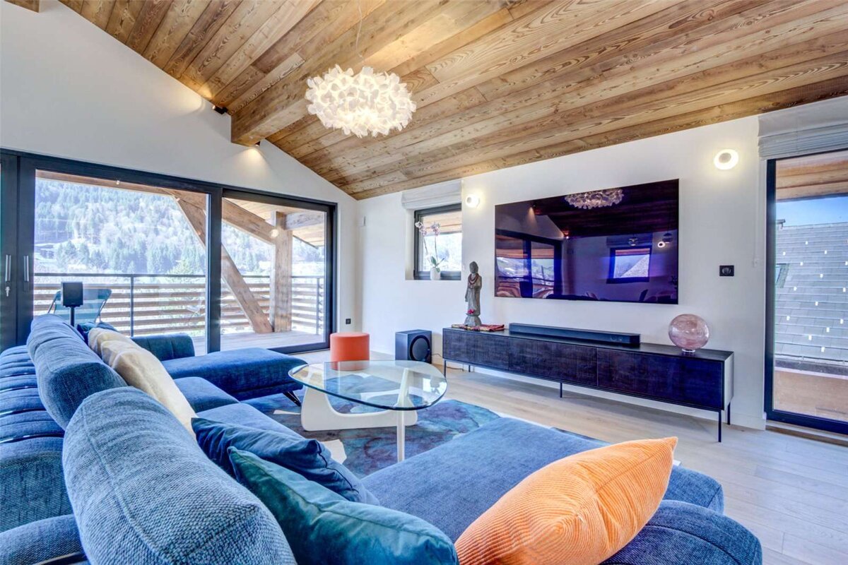 A living room with a blue couch and a flat screen tv