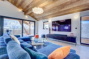 A living room with a blue couch and a flat screen tv