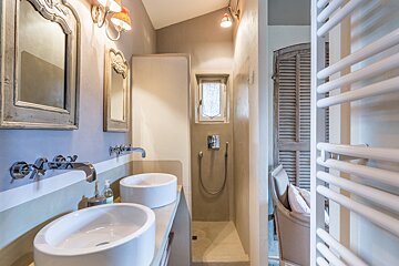 A bathroom with two sinks and a walk in shower