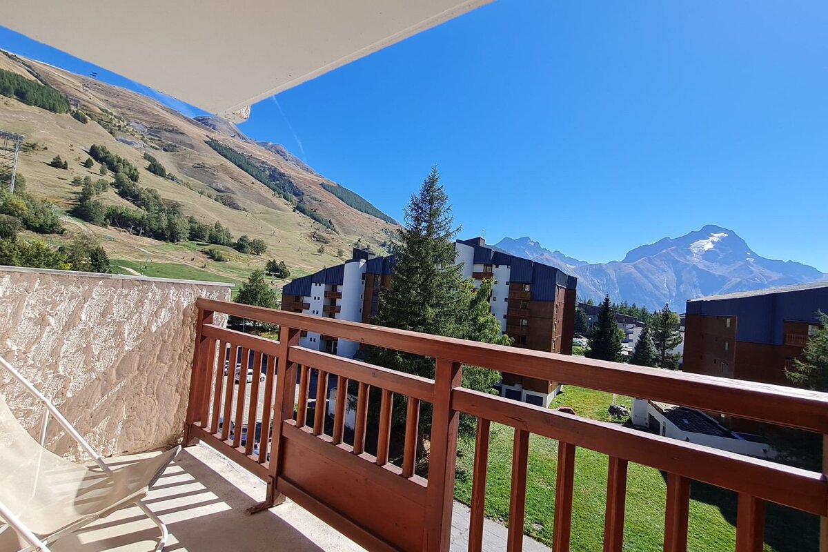 A balcony with a view of mountains and buildings