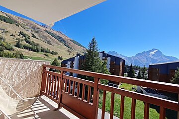 A balcony with a view of mountains and buildings