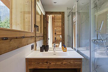 A bathroom with a sink a mirror and a shower