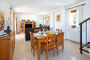 A dining room table with a bottle of wine on it