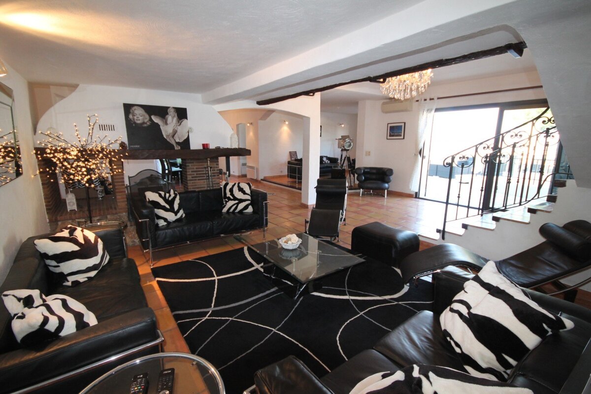 A living room with black and white furniture and a fireplace