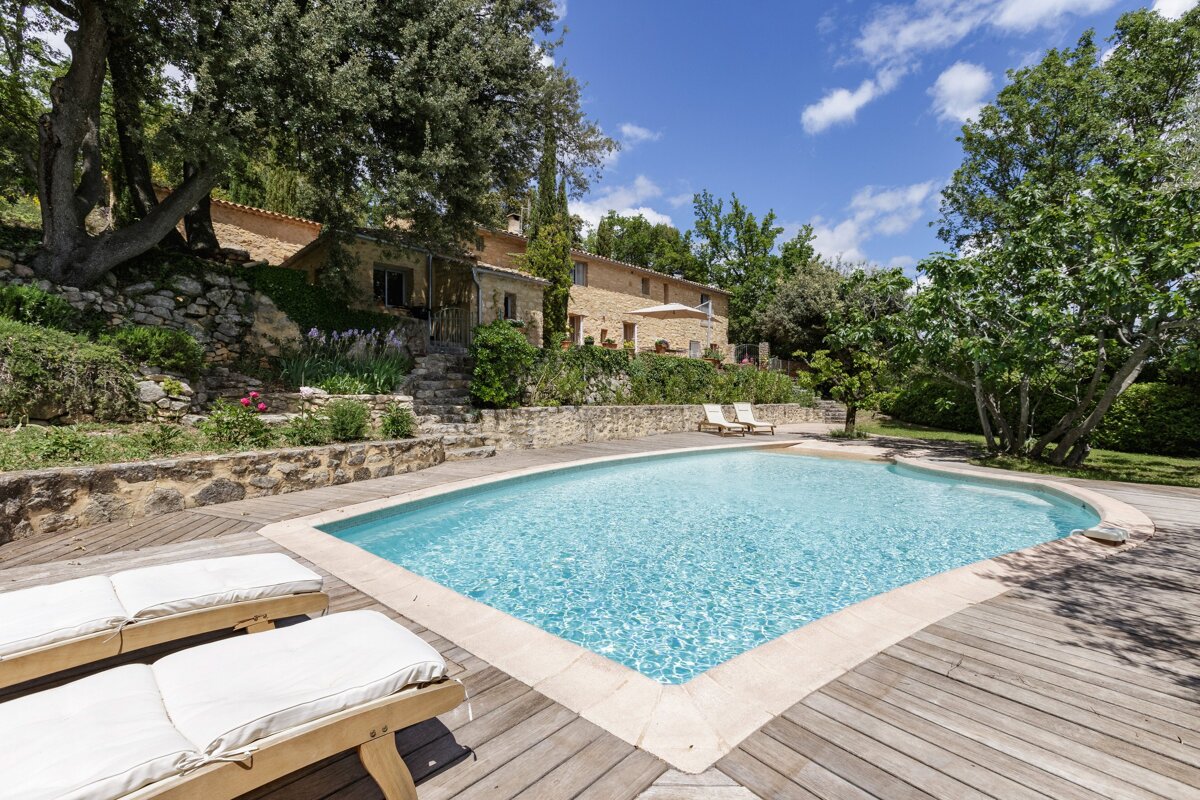 A large swimming pool with a house in the background