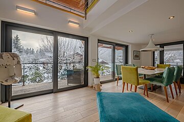 A living room with a table and chairs and a balcony