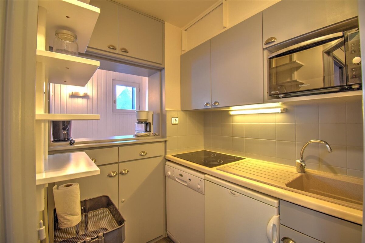A kitchen with a stove top oven and a microwave