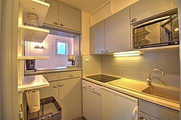 A kitchen with a stove top oven and a microwave