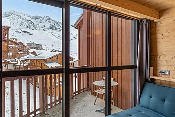 A balcony with a view of a snowy mountain range
