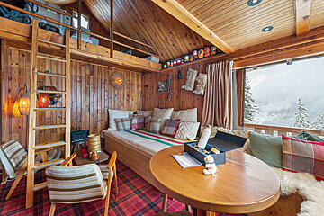 A wooden room with a bed and a table