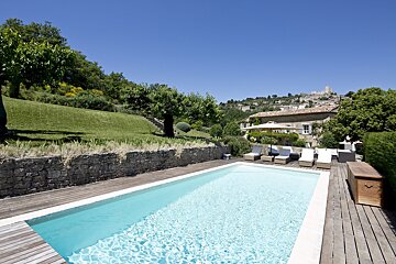 A large swimming pool with a house in the background