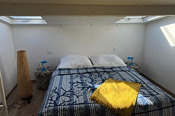 A bed with a blue and white striped blanket