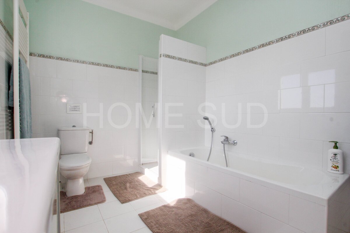 A bathroom with a toilet a bathtub and a sign that says home sud