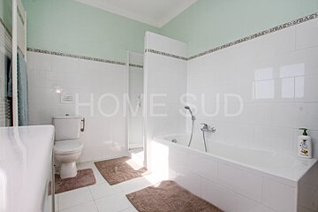 A bathroom with a toilet a bathtub and a sign that says home sud