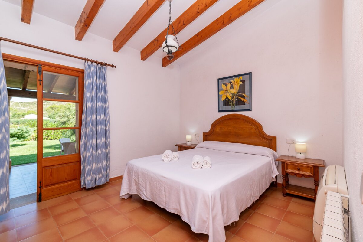 A bedroom with a large bed and a picture of a flower on the wall