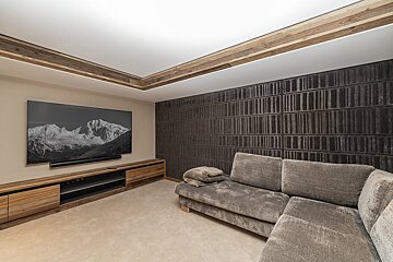 A room with wooden walls and shelves and a wooden bench
