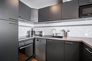 A kitchen with a brandt microwave above the sink