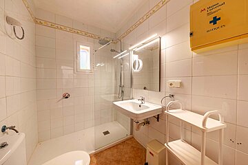 A bathroom with a yellow box that says botiquin on it