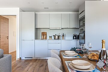 A bottle of champagne sits on a table in a kitchen