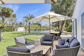 A white umbrella is sitting on a wooden deck