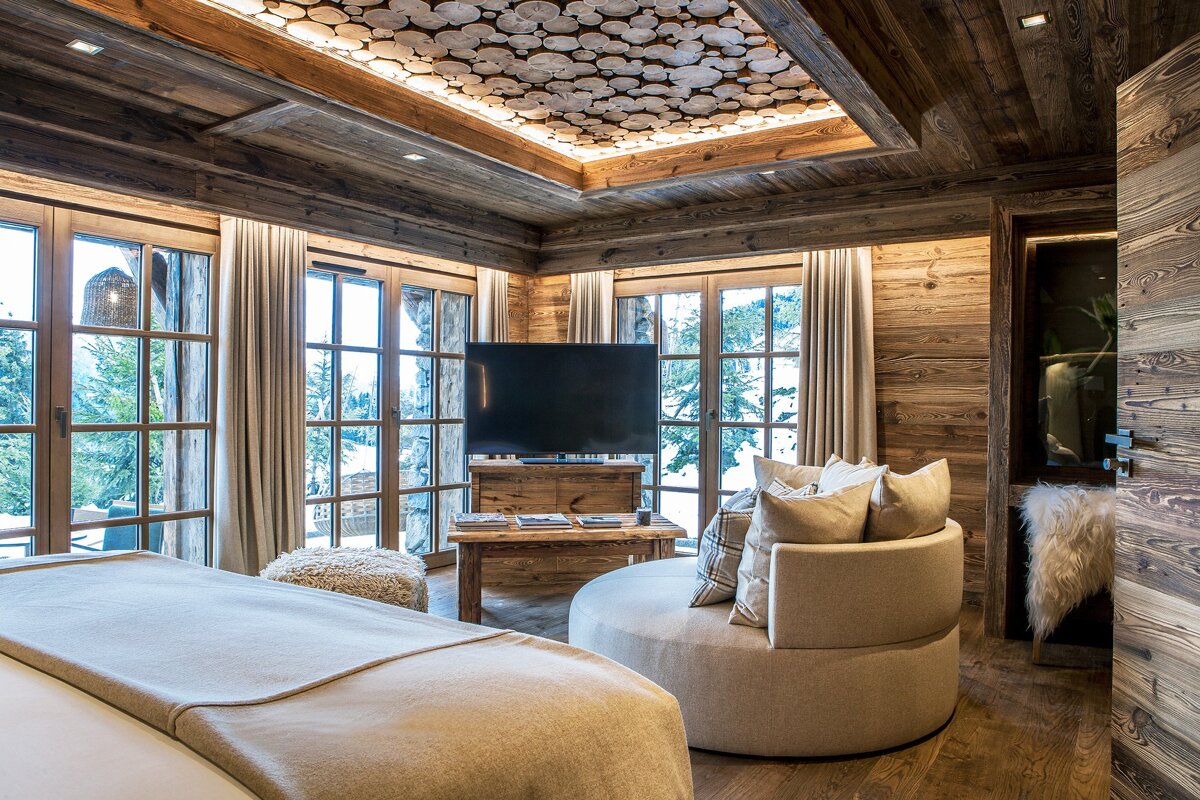 A bedroom with a round chair and a flat screen tv