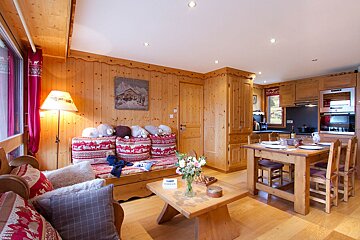 A living room with a couch and a table with a sign that says ' coca cola ' on it