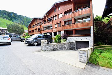 A large building with wooden balconies is covered in snow