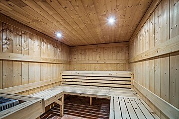 A wooden sauna with a bench and a heater